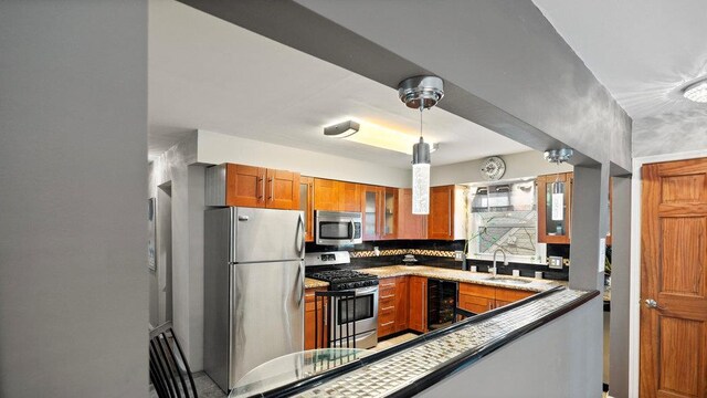 95 Foster Ave, Valley Stream, NY 11580 - kitchen featuring appliances with stainless steel finishes, brown cabinetry, glass insert cabinets, tasteful backsplash, and beverage cooler