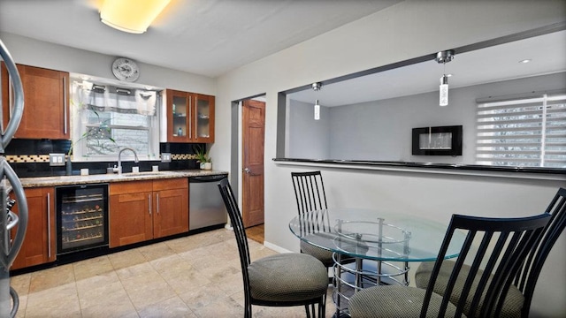95 Foster Ave, Valley Stream, NY 11580 - kitchen featuring beverage cooler, brown cabinets, dishwasher, and healthy amount of natural light