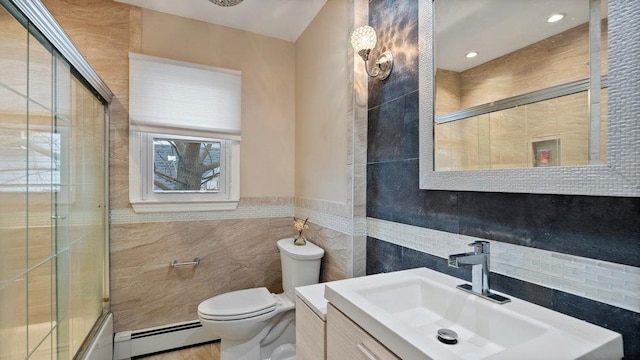 95 Foster Ave, Valley Stream, NY 11580 - bathroom featuring tile walls, baseboard heating, vanity, and combined bath / shower with glass door