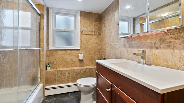 95 Foster Ave, Valley Stream, NY 11580 - full bath featuring a baseboard heating unit, tile walls, vanity, bath / shower combo with glass door, and tile patterned floors