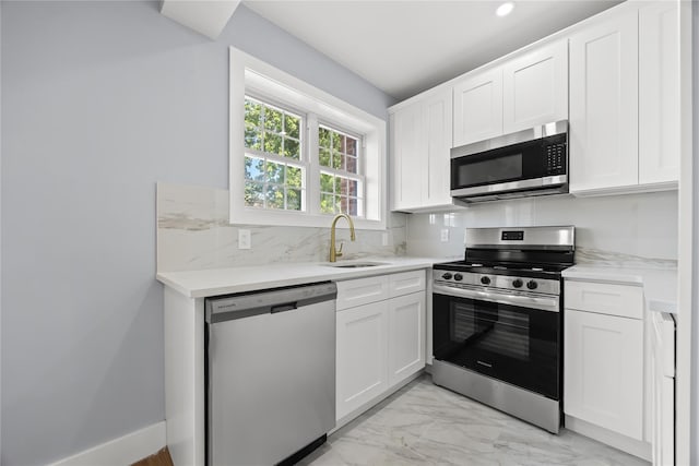24-08 97th St, East Elmhurst, NY 11369 - kitchen with appliances with stainless steel finishes, white cabinetry, backsplash, light countertops, and light marble finish flooring