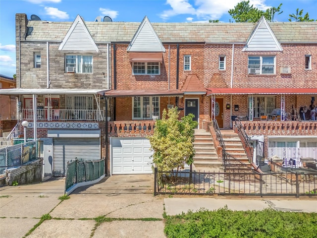 24-08 97th St, East Elmhurst, NY 11369 - view of property featuring driveway, a high end roof, an attached garage, and brick siding