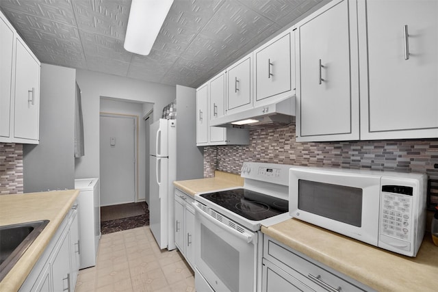17 Village Park Dr Unit 3A, Fishkill, NY 12524 - kitchen with white appliances, under cabinet range hood, an ornate ceiling, washer / clothes dryer, and backsplash