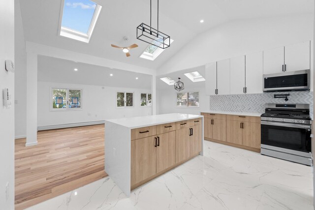 2572 Riverside Ave, Seaford, NY 11783 - kitchen featuring appliances with stainless steel finishes, a skylight, light brown cabinetry, a center island, and decorative backsplash