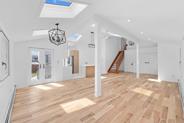 2572 Riverside Ave, Seaford, NY 11783 - entrance foyer featuring a skylight, lofted ceiling, baseboard heating, light wood-type flooring, and stairway