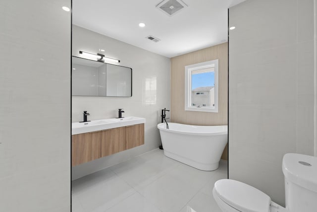 2572 Riverside Ave, Seaford, NY 11783 - bathroom featuring a freestanding bath, double vanity, and tile patterned floors