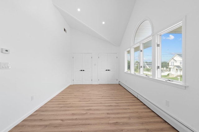 2572 Riverside Ave, Seaford, NY 11783 - unfurnished room with a baseboard heating unit, recessed lighting, light wood finished floors, and high vaulted ceiling