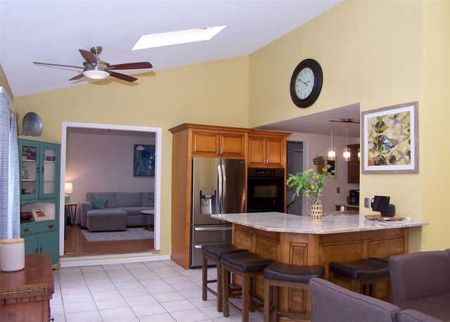 2189 Cedar Ave, Ronkonkoma, NY 11779 - kitchen featuring stainless steel fridge with ice dispenser, oven, a peninsula, ceiling fan, and a kitchen breakfast bar