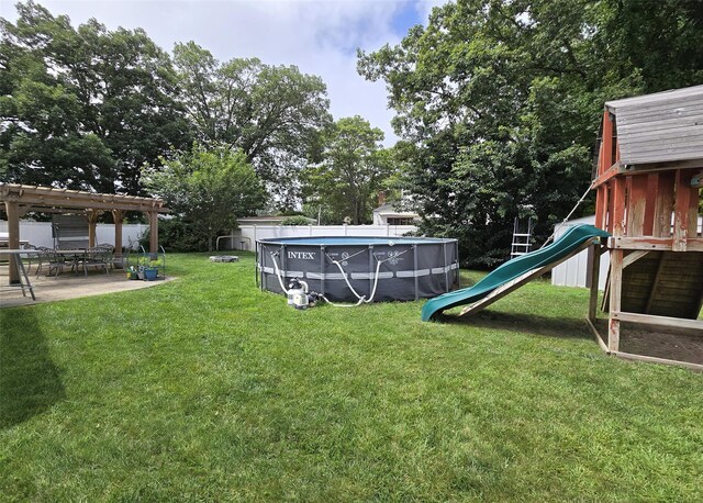 2189 Cedar Ave, Ronkonkoma, NY 11779 - view of green lawn featuring a playground, an outdoor pool, and a patio area