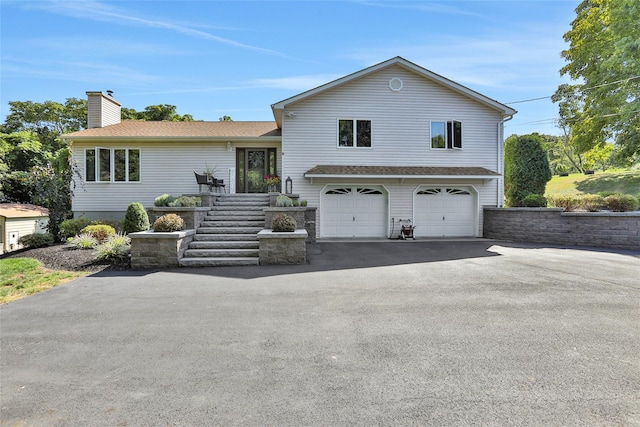 35 Lattintown Rd, Newburgh, NY 12550 - tri-level home with asphalt driveway, a chimney, an attached garage, and roof with shingles