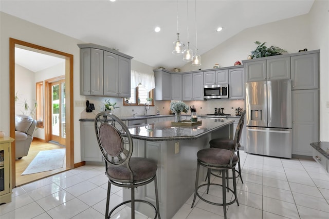 35 Lattintown Rd, Newburgh, NY 12550 - kitchen with stainless steel appliances, gray cabinetry, a kitchen bar, plenty of natural light, and lofted ceiling