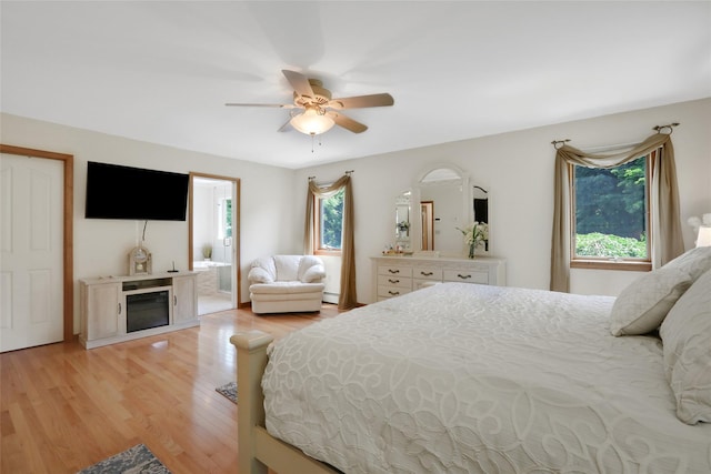 35 Lattintown Rd, Newburgh, NY 12550 - bedroom with baseboard heating, light wood-type flooring, ceiling fan, and a glass covered fireplace