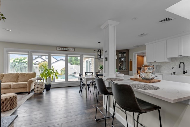 2854 Lenox Rd, Oceanside, NY 11572 - kitchen with ornate columns, healthy amount of natural light, white cabinetry, light stone countertops, and recessed lighting