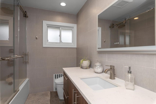 2854 Lenox Rd, Oceanside, NY 11572 - full bathroom featuring tile walls, shower / bath combination with glass door, vanity, and decorative backsplash