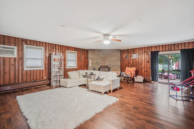 436 Oceanside St, Islip Terrace, NY 11752 - living area featuring baseboard heating, ceiling fan, wooden walls, wood finished floors, and a stone fireplace