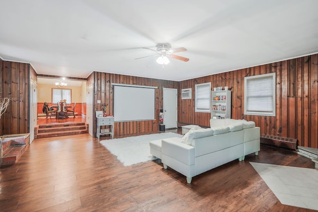 436 Oceanside St, Islip Terrace, NY 11752 - living area with a baseboard heating unit, wooden walls, a ceiling fan, a wall unit AC, and a chandelier