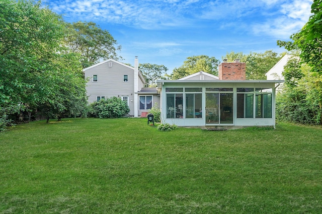 436 Oceanside St, Islip Terrace, NY 11752 - rear view of house featuring a chimney, a yard, and a sunroom