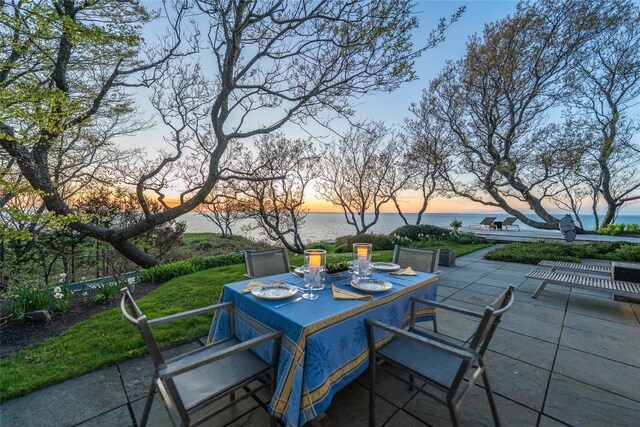 4105 Soundview Ave, Mattituck, NY 11952 - patio terrace at dusk featuring outdoor dining area, a patio, and a water view