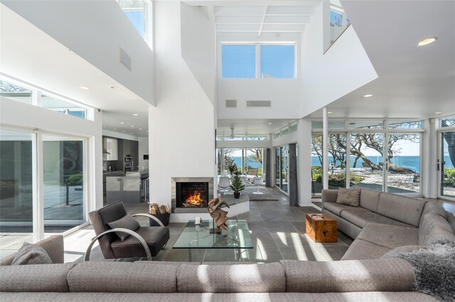 4105 Soundview Ave, Mattituck, NY 11952 - living room featuring a towering ceiling, healthy amount of natural light, a lit fireplace, and recessed lighting