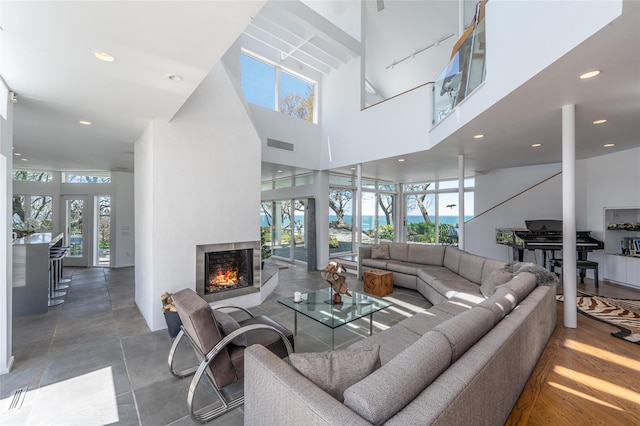 4105 Soundview Ave, Mattituck, NY 11952 - living room featuring a multi sided fireplace, a towering ceiling, recessed lighting, and rail lighting