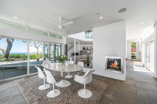 4105 Soundview Ave, Mattituck, NY 11952 - dining room featuring a ceiling fan, stone tile floors, a multi sided fireplace, and recessed lighting