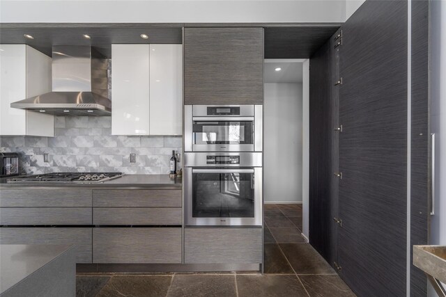 4105 Soundview Ave, Mattituck, NY 11952 - kitchen with wall chimney exhaust hood, modern cabinets, stainless steel appliances, white cabinetry, and decorative backsplash