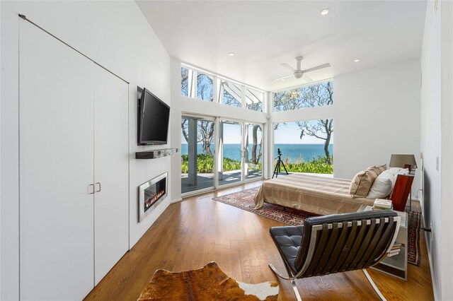 4105 Soundview Ave, Mattituck, NY 11952 - bedroom featuring access to exterior, a glass covered fireplace, wood finished floors, recessed lighting, and a ceiling fan