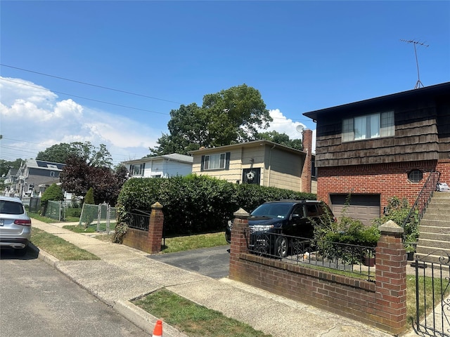8 Bainbridge St, Roosevelt, NY 11575 - split level home featuring an attached garage