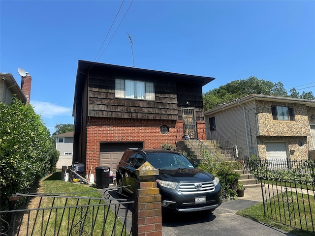 8 Bainbridge St, Roosevelt, NY 11575 - tri-level home with a garage, brick siding, and stairs