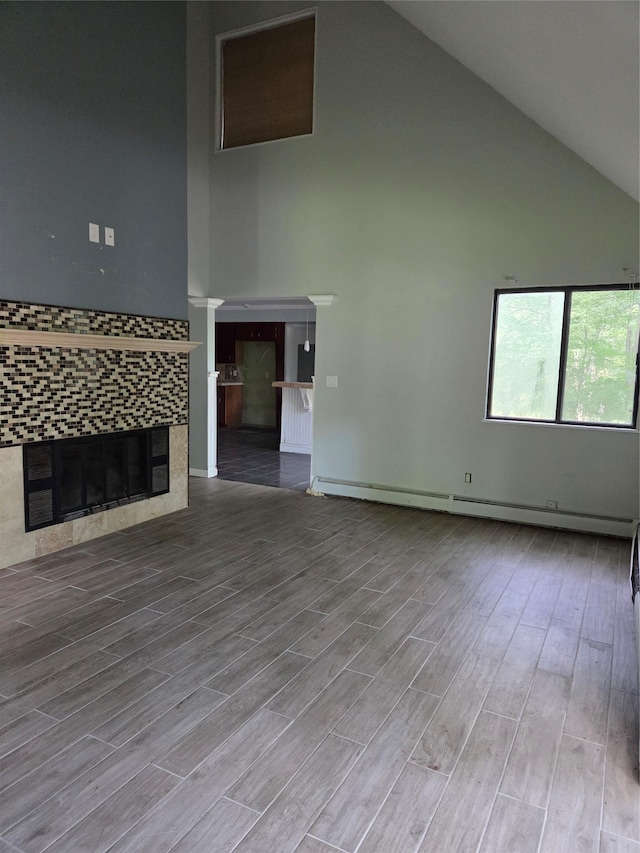 69 Mitchell Rd, Somers, NY 10589 - unfurnished living room with high vaulted ceiling, a fireplace, wood finished floors, and baseboard heating