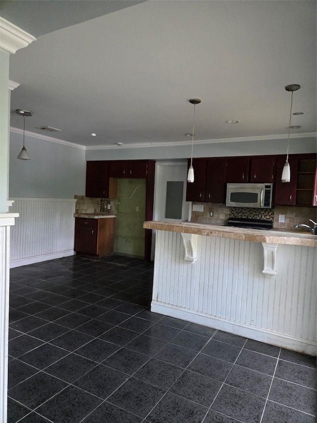 69 Mitchell Rd, Somers, NY 10589 - kitchen featuring stainless steel microwave, ornamental molding, dark tile patterned flooring, backsplash, and a wainscoted wall