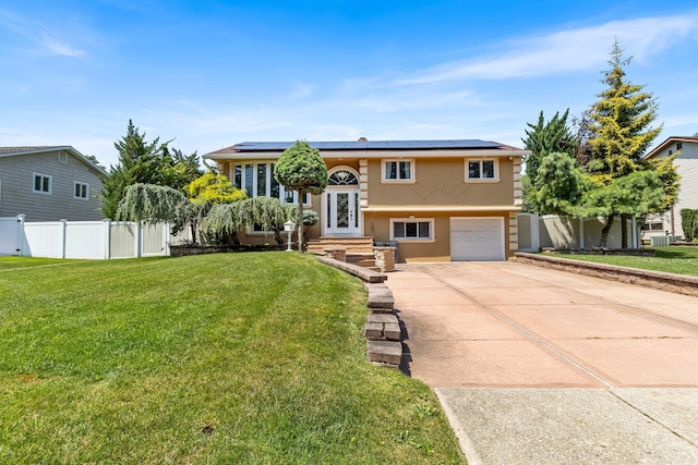 184 Overlook Dr, East Islip, NY 11730 - bi-level home with an attached garage, roof mounted solar panels, stucco siding, and driveway
