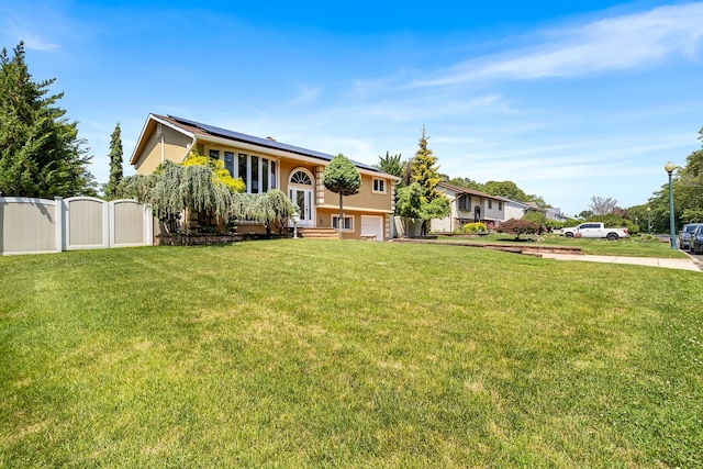 184 Overlook Dr, East Islip, NY 11730 - view of front of house with stucco siding, solar panels, a gate, and concrete driveway