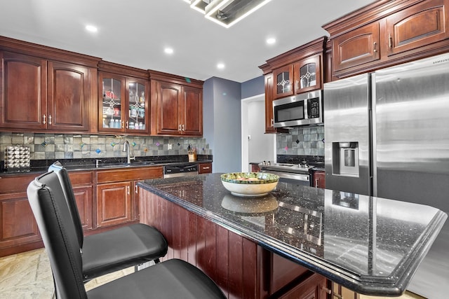 184 Overlook Dr, East Islip, NY 11730 - kitchen featuring stainless steel appliances, tasteful backsplash, glass insert cabinets, dark stone countertops, and a breakfast bar