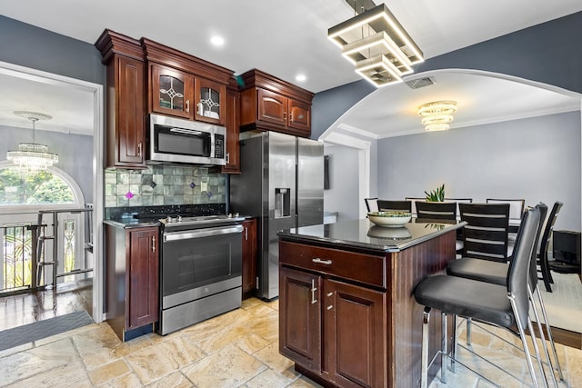 184 Overlook Dr, East Islip, NY 11730 - kitchen featuring stainless steel appliances, arched walkways, dark countertops, ornamental molding, and recessed lighting