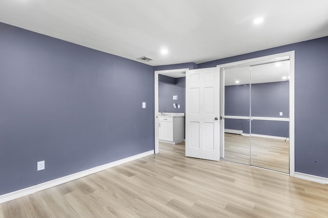 184 Overlook Dr, East Islip, NY 11730 - unfurnished bedroom featuring light wood-type flooring, a closet, recessed lighting, and a baseboard heating unit