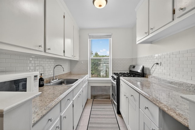4295 Webster Ave Unit 5J, Bronx, NY 10470 - kitchen with gas stove, light tile patterned floors, light countertops, and white cabinets