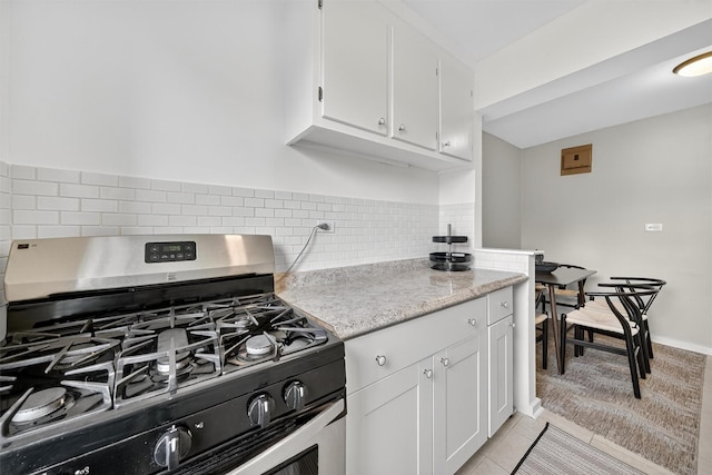 4295 Webster Ave Unit 5J, Bronx, NY 10470 - kitchen with stainless steel range with gas cooktop, white cabinetry, decorative backsplash, light tile patterned floors, and light stone countertops