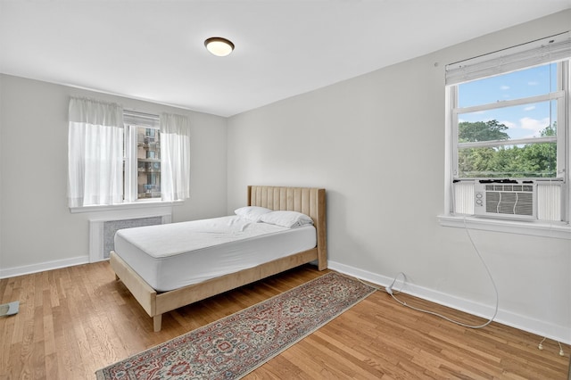 4295 Webster Ave Unit 5J, Bronx, NY 10470 - bedroom with radiator heating unit, wood finished floors, and cooling unit