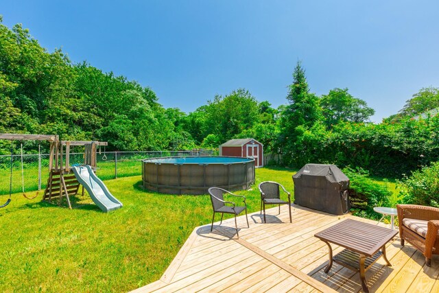 1191 E 3rd Ave, Bay Shore, NY 11706 - deck featuring a fenced backyard, a grill, a storage unit, and a playground