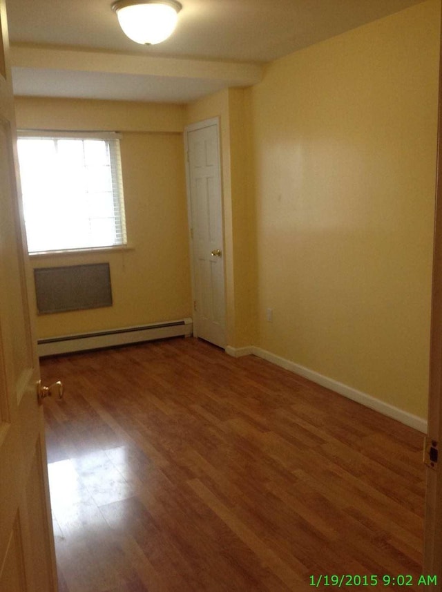 8502 57th Rd, Elmhurst, NY 11373 - spare room with a baseboard radiator and wood finished floors