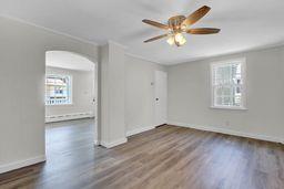 10 Valentine St, Glen Cove, NY 11542 - unfurnished room with healthy amount of natural light, arched walkways, wood finished floors, and ceiling fan
