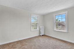 10 Valentine St, Glen Cove, NY 11542 - carpeted empty room with radiator and baseboards