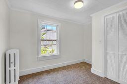 10 Valentine St, Glen Cove, NY 11542 - unfurnished bedroom featuring radiator heating unit, ornamental molding, a closet, and carpet floors
