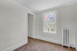 10 Valentine St, Glen Cove, NY 11542 - empty room featuring radiator and crown molding