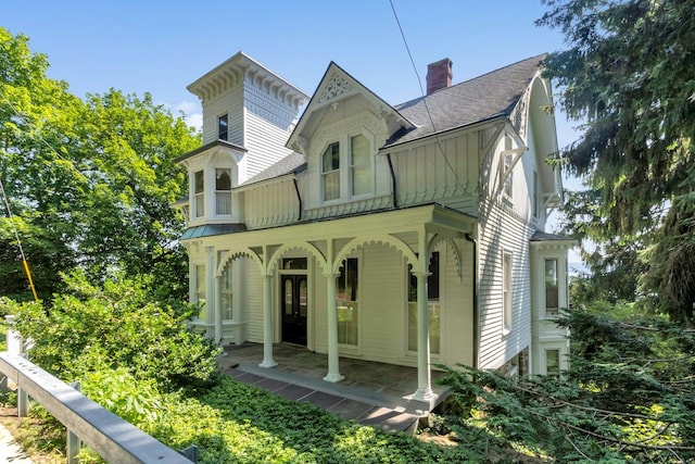 165 River Rd, Nyack, NY 10960 - view of front facade featuring roof with shingles, covered porch, board and batten siding, a chimney, and a standing seam roof