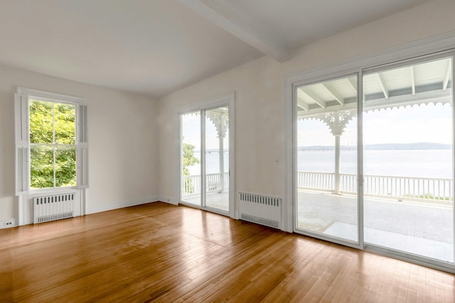 165 River Rd, Nyack, NY 10960 - empty room with radiator heating unit, wood-type flooring, a water view, and beamed ceiling