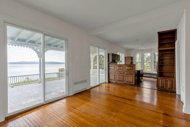 165 River Rd, Nyack, NY 10960 - unfurnished living room featuring radiator heating unit, light wood-style flooring, and a water view
