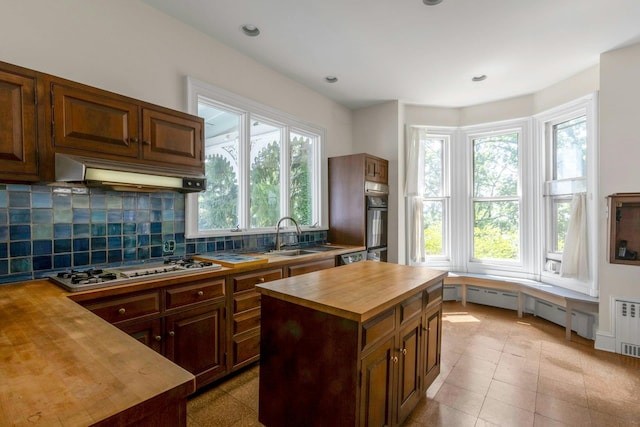 165 River Rd, Nyack, NY 10960 - kitchen featuring wood counters, under cabinet range hood, white gas stovetop, decorative backsplash, and black oven