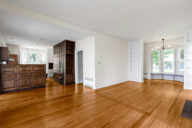 165 River Rd, Nyack, NY 10960 - unfurnished living room with light wood-style floors, a chandelier, and radiator heating unit